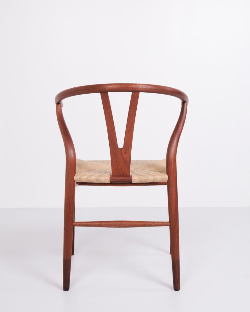 May include: A wooden chair with a curved back and woven seat. The chair's frame is a rich brown color, and the seat is made of a light tan woven material. The back of the chair has a distinctive Y-shaped design.