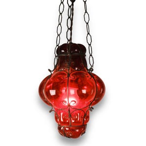 May include: A red glass chandelier with a metal frame and multiple bulbs. The chandelier is hanging from a chain.