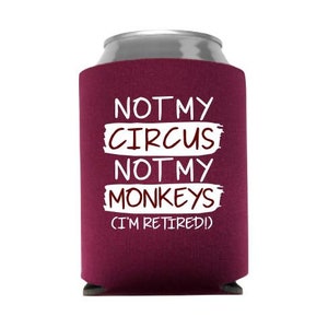 May include: A maroon can cooler with the text "Not my circus, not my monkeys (I'm retired)" in white.