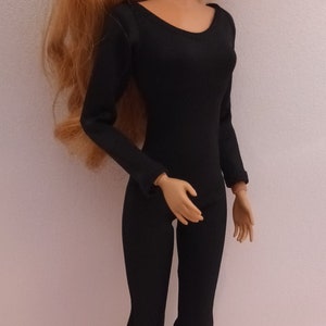 May include: A doll wearing a black long-sleeved leotard with a scoop neck. The doll has long, wavy, auburn hair and is wearing white earrings.
