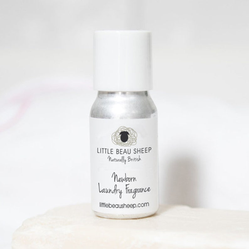 May include: A small, silver-colored bottle with a white cap. The label reads "LITTLE BEAU SHEEP Naturally British" and "Newborn Laundry Fragrance". The bottle is designed for laundry use and has a clean, minimalist aesthetic.