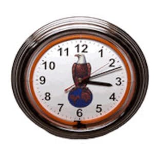 Puede incluir: Un reloj redondo blanco con un marco cromado y un anillo exterior naranja. La esfera del reloj presenta un águila calva posada sobre un globo terráqueo. El águila es marrón y blanca con un pico rojo y patas amarillas. Las manecillas del reloj son negras.