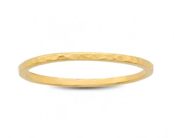May include: A thin, gold-colored ring with a hammered texture. The ring is a simple band design, with a slightly rounded shape. The gold color is bright and shiny, reflecting light. The ring is likely made of metal.