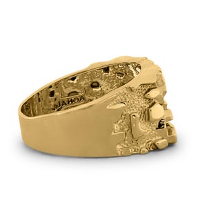 May include: A gold ring with a textured design. The ring is marked with the word "JAHOA" on the inside.