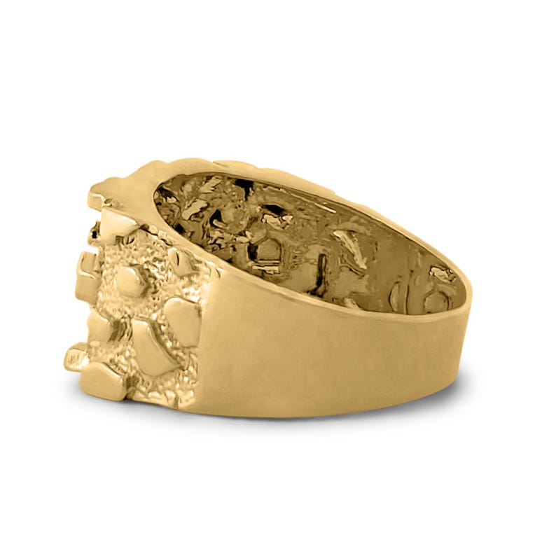 May include: A gold ring with a textured, nugget-like design. The ring is thick and has a wide band.