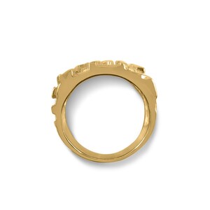May include: A gold ring with a textured design. The ring is made of a single band and has a smooth, polished finish.