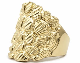 May include: A gold ring featuring a prominent, textured nugget-style design on the face. The surface of the ring is composed of multiple raised, irregular, and polished gold segments that create a layered, three-dimensional appearance.
