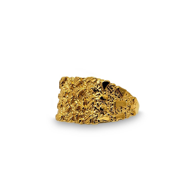May include: A gold ring with a textured, nugget-like design. The ring is wide and has a flat top.