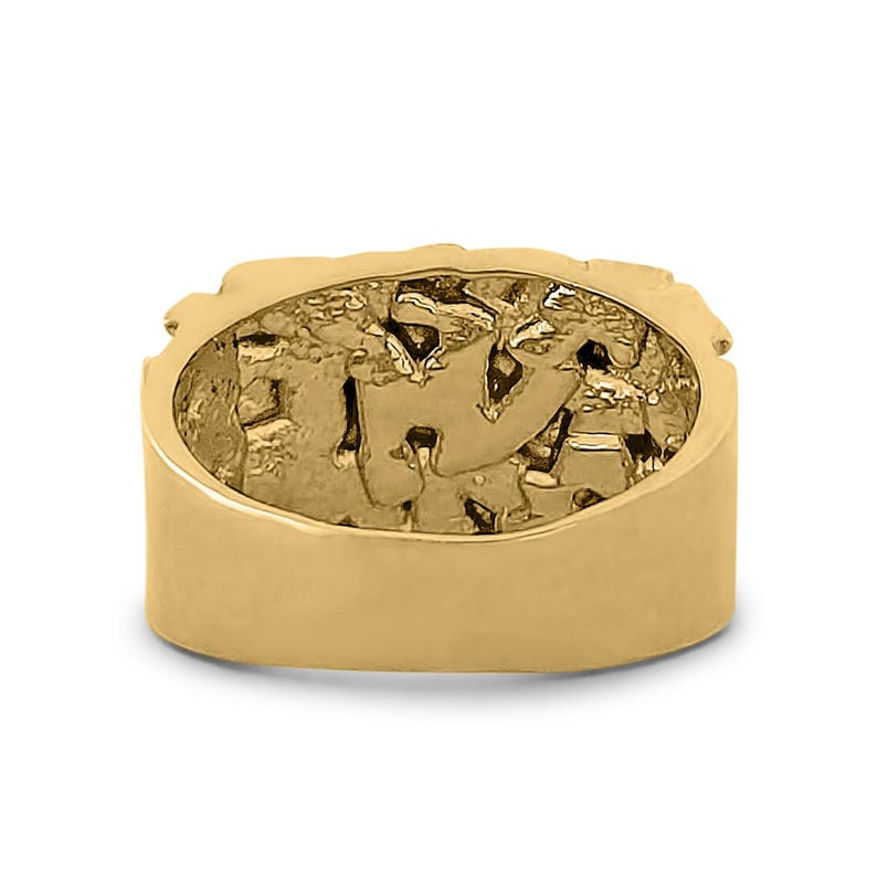 May include: A gold-colored ring with a detailed design on the top. The ring is thick and has a smooth, polished finish.