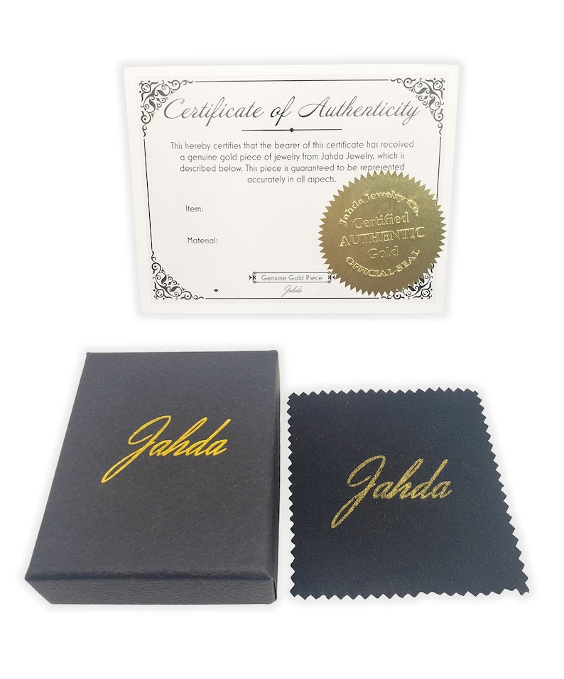 May include: A black box with the word "Jahda" in gold lettering. The box is next to a black polishing cloth with the same gold lettering. A certificate of authenticity with a gold seal that reads "Certified Authentic Gold Official Seal" is also included.