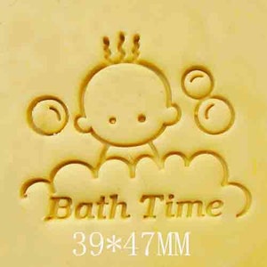 May include: A yellow rubber stamp with a cartoon baby in a bathtub with bubbles. The stamp says "Bath Time" and measures 39 x 47 mm.
