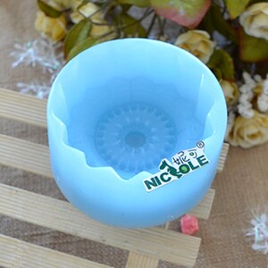 Pu&ograve; includere: Uno stampo in silicone blu chiaro con un design decorativo al centro. Lo stampo ha un bordo a festoni e le parole "Nicole" e un logo sono stampate sul lato.