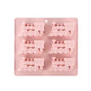 May include: Pink silicone mold with six cavities shaped like train engines. Each cavity has a detailed design of a train engine with wheels, a smokestack, and a cab.