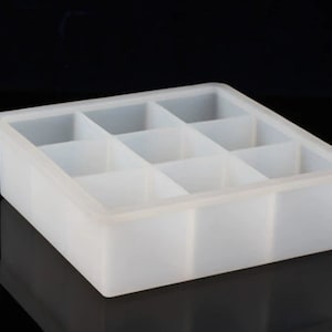 Può includere: Uno stampo in silicone bianco con nove scomparti quadrati. Lo stampo è progettato per fare cubetti di ghiaccio, cioccolato o altri piccoli dolcetti.