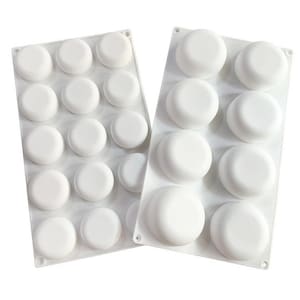 May include: Two white silicone baking moulds with round cavities. The mould on the left has 15 cavities and the mould on the right has 6 cavities.