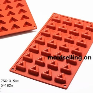 May include: A red silicone mold with 30 triangle-shaped cavities. The mold measures approximately 11.8 x 6.9 x 0.5 inches. The text "moldselling on etsy" is printed on the mold.