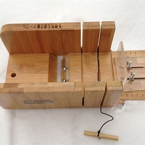 May include: A wooden soap cutter with a clear plastic guide and a ruler marked in inches. The cutter has a string attached to it and a small wooden dowel.
