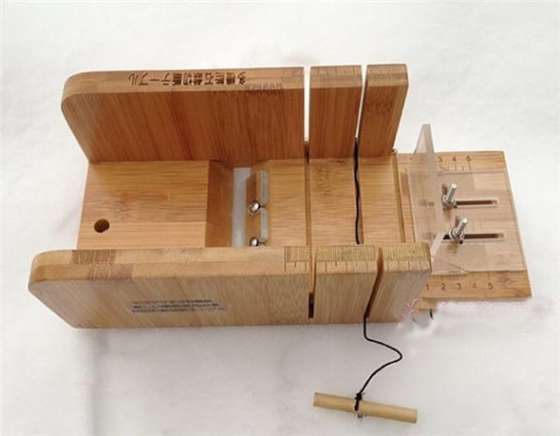 May include: A wooden soap cutter with a clear plastic guide and a ruler marked in inches. The cutter has a string attached to it and a small wooden dowel.
