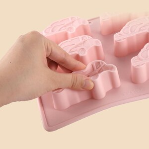 May include: Pink silicone mold with six car-shaped cavities. The mold is flexible and easy to use.