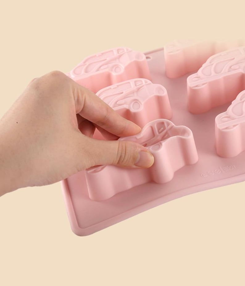 May include: Pink silicone mold with six car-shaped cavities. The mold is flexible and easy to use.