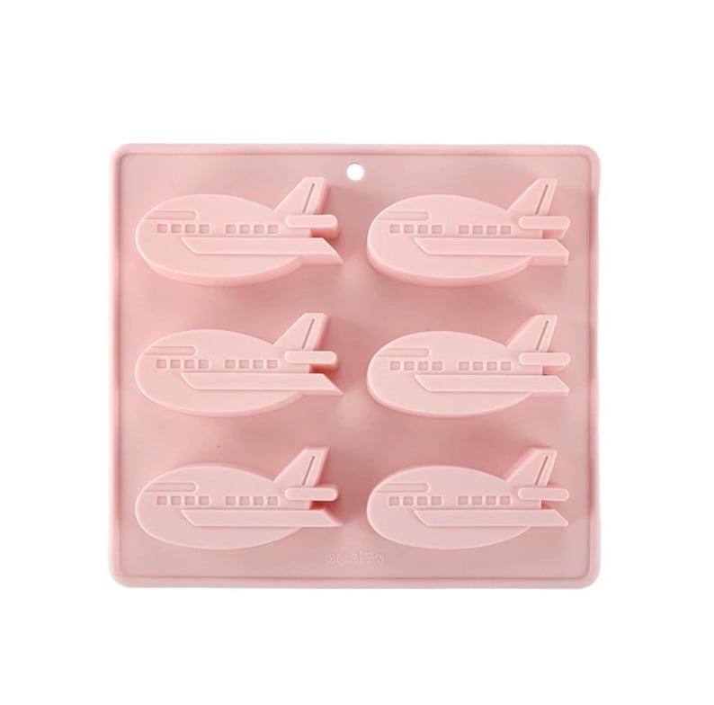 May include: Pink silicone mold with six airplane-shaped cavities. The mold is designed for making chocolate or candy.