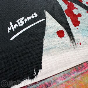 May include: An abstract painting in black and white with red paint splatters. The painting is signed "MaBanks" in white paint.