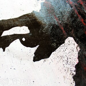 May include: Abstract art painting with black, white, and red paint splatters on a white canvas. The black paint is thick and textured, creating a dramatic effect.