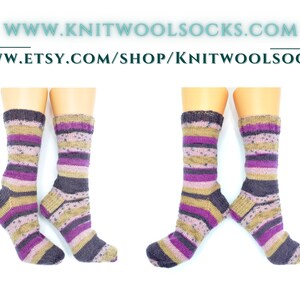 Puede incluir: Par de calcetines de lana a rayas en tonos de morado, marr&oacute;n y beige. Los calcetines se muestran sobre un fondo blanco.