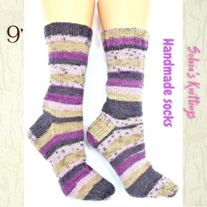 Puede incluir: Un par de calcetines a rayas hechos a mano en tonos de morado, marr&oacute;n y beige. Los calcetines miden 23 cm de largo y est&aacute;n hechos a mano.