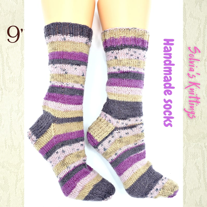Puede incluir: Un par de calcetines a rayas hechos a mano en tonos de morado, marr&oacute;n y beige. Los calcetines miden 23 cm de largo y est&aacute;n hechos a mano.