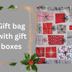 May include: A gray and white gift bag with a red and white patterned design of gift boxes. The bag has a drawstring closure and is decorated with holly and berries.