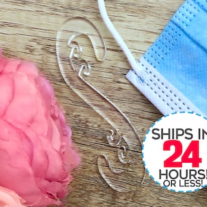 May include: Clear plastic face mask holder with a curved design. The holder is designed to help keep the ear loops of a face mask off the ears.  Ships in 24 hours or less.