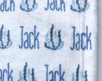 May include: White baby blanket with a blue and white seahorse pattern. The blanket is personalized with the name "Jack" repeated throughout.