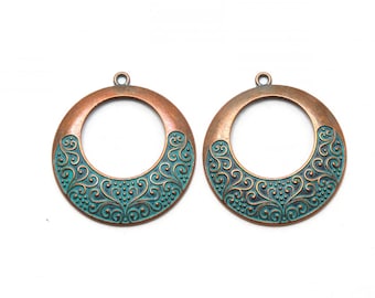 May include: Two copper-colored metal circles with a teal-colored design. The circles have a hole at the top for hanging.