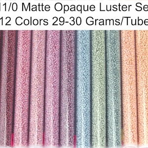 May include: Set of 12 tubes of 11/0 size matte opaque luster seed beads. Each tube contains 29-30 grams of beads. The beads are arranged in a rainbow color gradient from dark red to light peach.