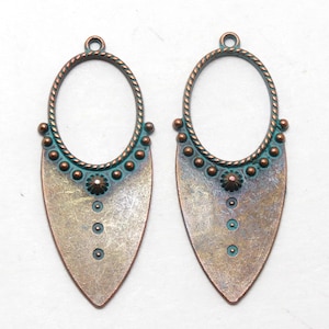 May include: Two antique copper and teal colored metal earring blanks with a teardrop shape and a round opening at the top.