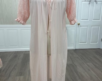 May include: A long, pink, lace-trimmed robe with a tie closure. The robe has a sheer lace overlay on the sleeves and a satin-like finish.