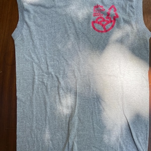 May include: Gray sleeveless t-shirt with a crew neck. The shirt features a pink graphic on the chest that reads "Nice Moose Groove". The shirt is made of a soft, lightweight material.