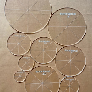 May include: A set of nine clear acrylic circle templates for quilting or crafting. The templates are marked with the Storts Market brand name and range in size from 2 1/2 inches to 6 inches.