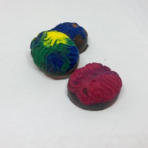May include: Three round, colorful, textured, rubber stamps. The stamps are red, blue, and yellow with green accents. The stamps are designed with a wavy pattern.