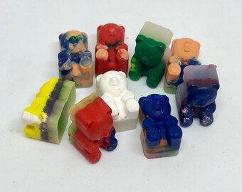May include: A collection of ten small, colorful, crayon-like bear figurines. The bears are in various poses and colors, including red, blue, green, yellow, white, and purple.