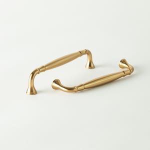 May include: A set of three ceramic mugs with a speckled, cream-colored glaze. Each mug features a different hand-painted floral design in shades of blue, green, and yellow. The mugs have a simple, rounded shape and a comfortable handle.