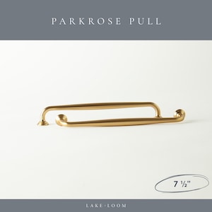 以下が含まれることがあります： 白い背景に、長さ19cmの2つのゴールドカラーのParkroseプルが表示されています。プルは、丸みを帯びた端とマット仕上げの曲線的なデザインです。「PARKROSE PULL」と「LAKE LOOM」の文字が見えます。