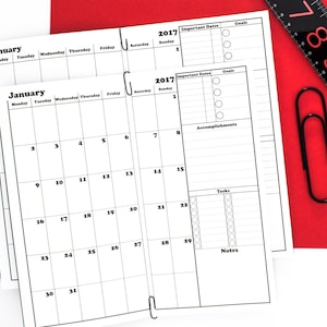 May include: A black and white planner with a January 2017 calendar, important dates, goals, accomplishments, tasks, and notes sections. The planner is open to the January page and has a black paperclip attached to the top.