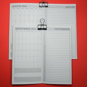 May include: A close-up of a two-page calendar spread for August and September 2016. The calendar is printed on white paper with black text and lines. The pages are held together with two black binder clips.