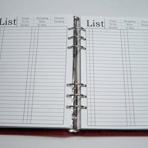 May include: A white planner with a red cover and silver rings. The planner has two pages open, each with a list titled "List" and columns for "Guest To Do Bucket", "Shopping Wish To Buy", and "Grocery Packing".