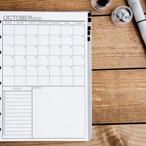May include: A black and white monthly planner with a calendar for October 2020. The planner has a to-do list and notes section.