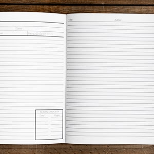 May include: A white reading journal with lined pages and a section for tracking books read. The journal has a black cover with the words "Reading Journal" printed on the front.