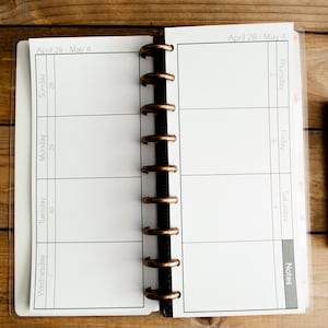 May include: A white weekly planner with a black and copper coil binding. The planner has a clear plastic cover and the dates "April 28 - May 4" are printed at the top.