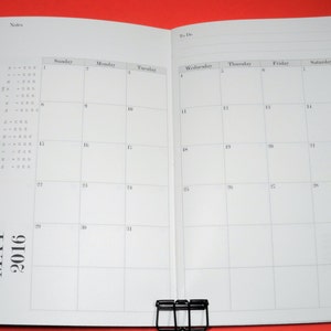 Peut inclure: Un planificateur mensuel de calendrier vierge pour mai 2016. Le calendrier comporte une section de notes sur la page de gauche et une section de liste de tâches sur la page de droite. Le calendrier est divisé en jours de la semaine, chaque jour ayant un espace vide pour écrire.